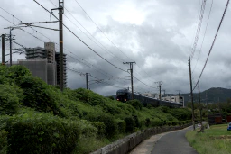 A train entering Torokko Kameoka Station on a cloudy, windy day.